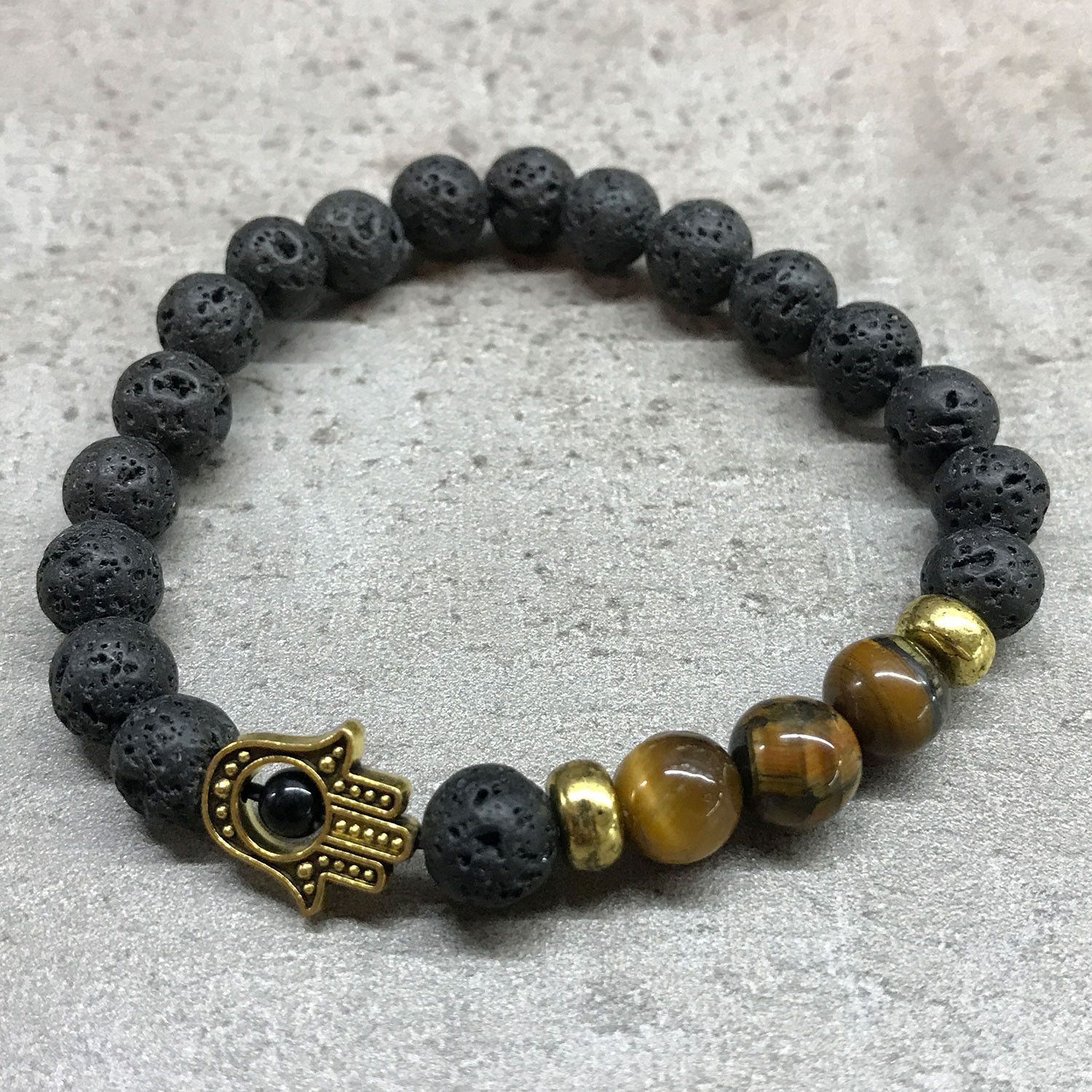 bG9jYWw6Ly9tZWRpYS8xSi9KQy82MFIzMEMxRzZNVDNKQzFKLzkzOTk2YjBlLmpwZWc.jpg Lava Stone Bracelet - Hamsa Tiger-eye - Image 2